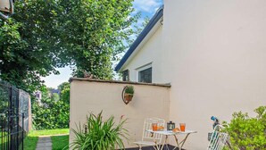 A patio with a table and chairs, potted plants, and a small garden area. - 1 Bed in Penmaenmawr (oc-95495) (Penmaenmawr)