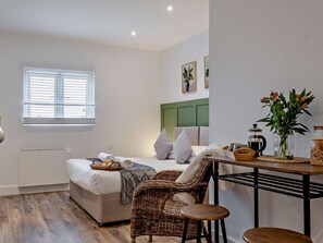 A modern bedroom with a bed, a dining table, and a wicker chair. - 1 Bed in Newport (oc-95453) (Newport)