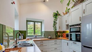 Eine moderne Küche mit großem Fenster, Edelstahlgeräten und einer Holzarbeitsplatte.