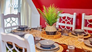 Une table à manger dressée avec des assiettes, des verres et un set de table en fibres tressées.