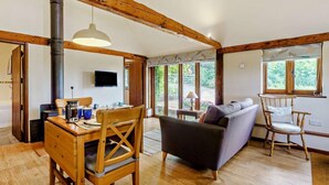 Una habitación acogedora con una mesa de comedor de madera, un sofá y una televisión.