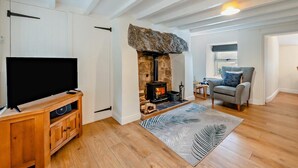 A living room with a stone fireplace, wooden flooring, a television, and a sofa. - 2 Bed in Corwen (oc-95542) (Corwen)