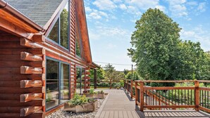 A wooden deck leading to a log cabin with large windows and a wooden railing. - 4 Bed in Kippford (oc-95234) (Kippford)