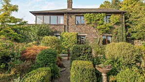 A stone house with a garden pathway leading to the entrance. - 4 Bed in Kendal (oc-95607) (Crosthwaite)