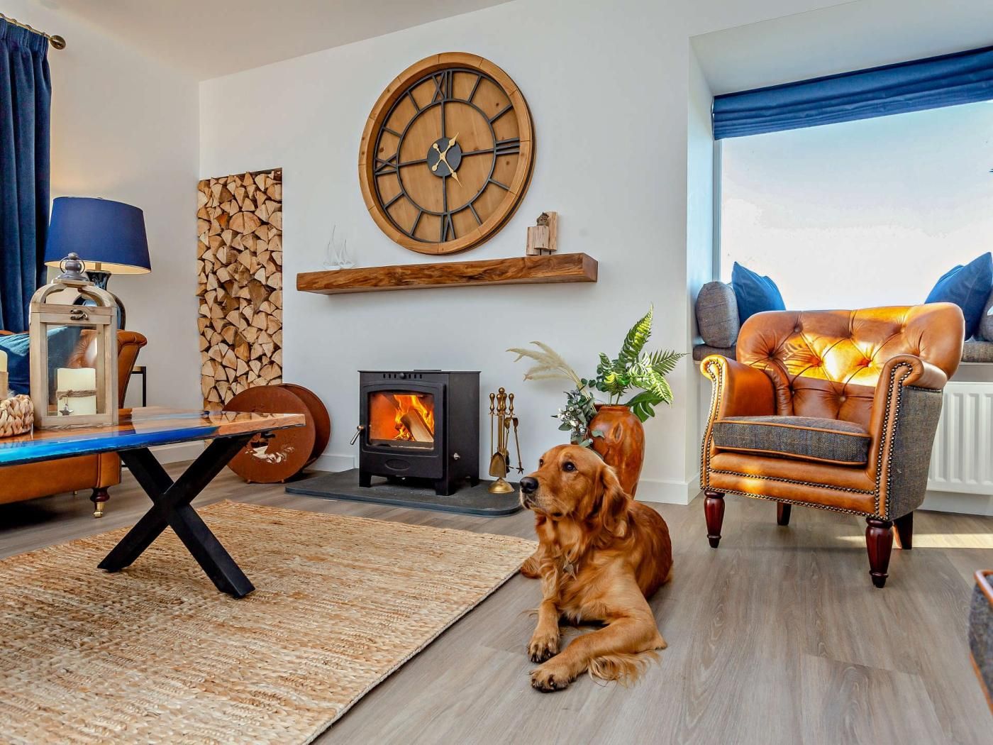 Ein gemütliches Wohnzimmer mit Kamin, einer großen Wanduhr und einem Hund.