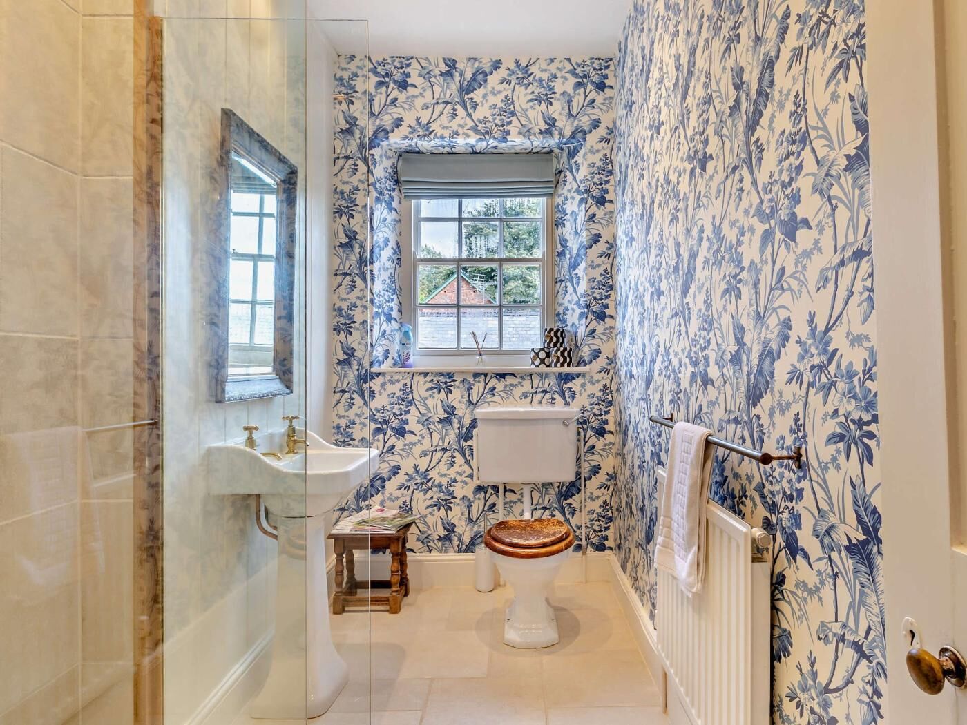 Une salle de bain avec des toilettes, un lavabo et une fenêtre.