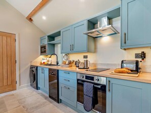 Eine moderne Küche mit hellblauen Schränken, einem eingebauten Backofen, einer Mikrowelle und einem Toaster.
