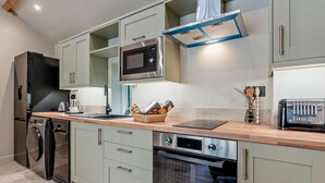 Uma cozinha moderna com micro-ondas, forno e lava-louças embutidos, e uma torradeira na bancada.