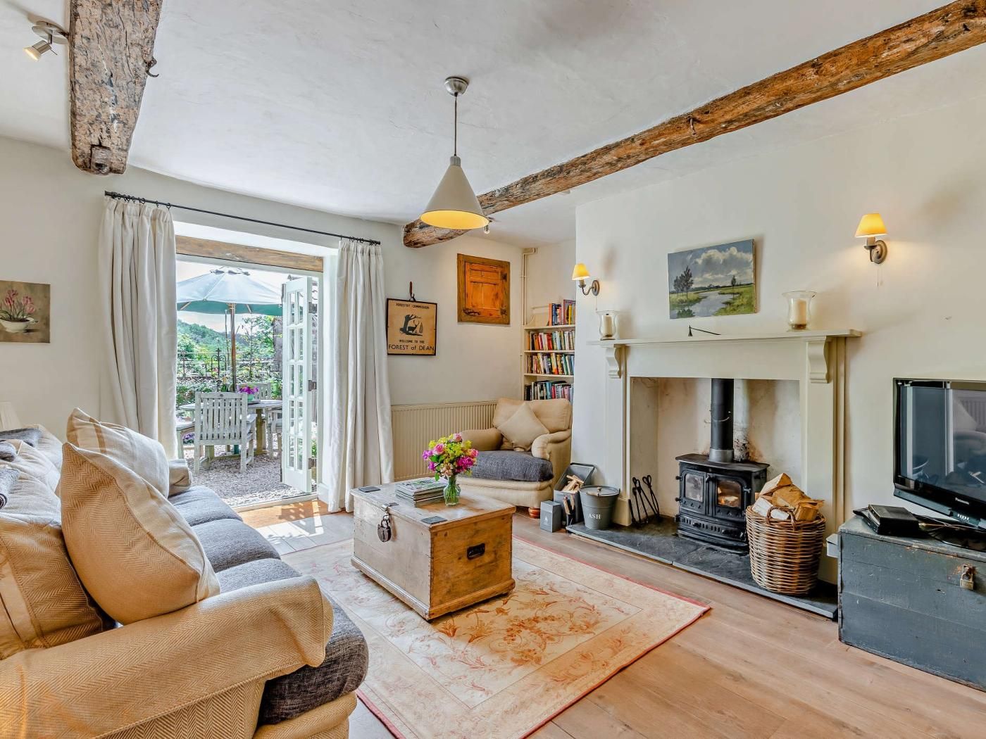 A cozy living room with a sofa, a fireplace, a television, and a bookshelf.