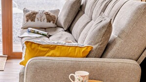 Ein Sofa mit Kissen, einer Tasse und einem Buch.
