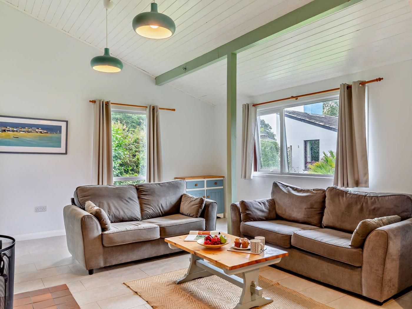 A living room with two sofas, a coffee table, and a painting on the wall.