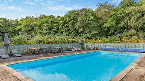 A rectangular swimming pool with a clear blue water surface, surrounded by a stone deck. - 2 Bed in Saltash (oc-95642) (Notter)