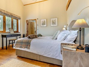 Ein Schlafzimmer mit einem Bett, einem Nachttisch, einer Lampe und einem Schreibtisch mit Stuhl.