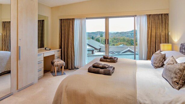 Een hotelkamer met een bed, een bureau, een stoel en uitzicht op het omliggende.