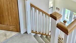 A staircase with white railings and wooden handrails, leading to an upper floor. - Countryside Garden Loft near Lymm (Warrington)