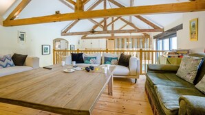 A spacious room with a high ceiling, wooden beams, a large wooden table, and two sofas. - 3 Bed in Shaftesbury (oc-95685) (Sedgehill)