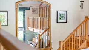 A staircase with wooden railings leading to a second-floor area with a piano and framed artwork on the walls. - 3 Bed in Shaftesbury (oc-95685) (Sedgehill)