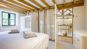 A bedroom with a bed, a wardrobe, a window, and a wooden balcony. - 3 Bed in Shaftesbury (oc-95685) (Sedgehill)