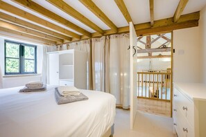 Ein Schlafzimmer mit einem Bett, einem Kleiderschrank, einem Fenster und einem Holzbalkon.