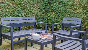 A patio with two grey chairs and a table, a teapot, and a plate with food and two cups. - 2 Bed in Keswick (oc-95741) (Keswick)