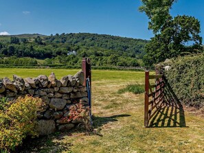 A stone wall with a gate, a grassy field, and a hill in the background. - 3 Bed in Conwy (oc-83154) (Rowen)