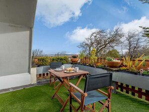A patio with a table and chairs, a view of the landscape, and potted plants. - 3 Bed in Bideford (oc-lakco) (Northam)