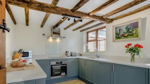 Una cocina con techo de madera, ventana y un cuadro en la pared.