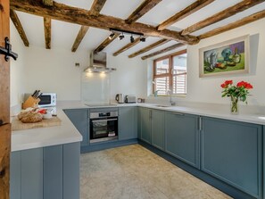 Eine Küche mit Holzboden, einem Fenster und einem Bild an der Wand.