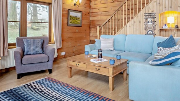 Un intérieur en bois avec un canapé, une table basse et un escalier.