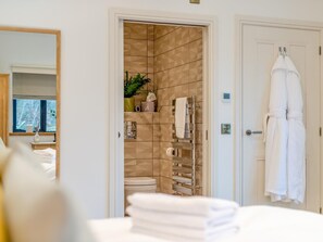 Ein Badezimmer mit Toilette, Handtuchhalter und Spiegel.