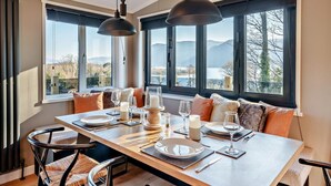 A dining area with a table set for four, large windows, and a view of the outdoors. - 2 Bed in Keswick (oc-95813) (Bassenthwaite)