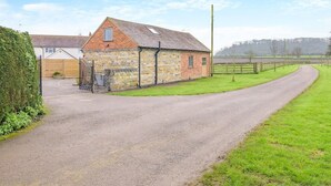 A rural road leading to a stone building with a sloped roof and a small window. - 1 Bed in Gloucester (oc-95793) (Tirley)