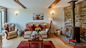 A cozy living room with a sofa, armchairs, a coffee table, a fireplace, and a painting on the wall. - 2 Bed in Llanidloes (oc-95815) (Llanidloes Without)