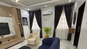 Uma sala de estar moderna com sofá, televisão e aparelho de ar condicionado.