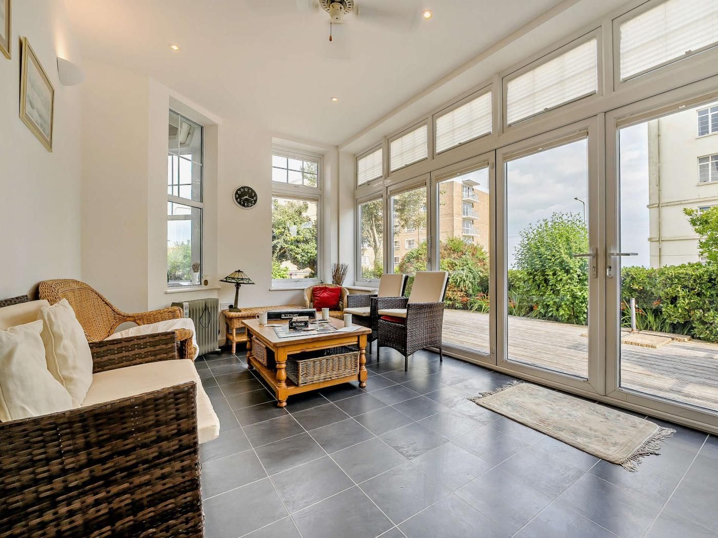 A spacious living room with a large window, a sofa, a coffee table, and a dining area.