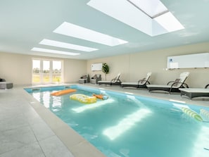 Una piscina interior amb gandules i joguets inflables.