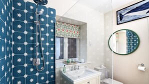 Ein Badezimmer mit Dusche, Waschbecken, Toilette und Spiegel.