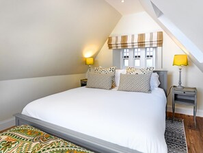 A bedroom with a large bed, two bedside tables with lamps, a window with blinds, and a patterned rug. - 3 Bed in Lockerbie (oc-95861) (Hoddom)