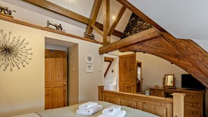 A bedroom with a bed, a wooden ceiling, a mirror, and a dresser. - 2 Bed in Ambleside (oc-95914) (Hawkshead)