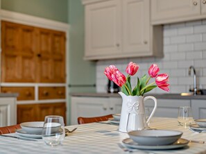 A dining table set with plates, glasses, and a pitcher of flowers. - 2 Bed in Ambleside (oc-95914) (Hawkshead)