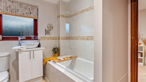 Een badkamer met toilet, wastafel en bad.
