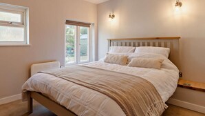 A bedroom with a bed, a window, a door, and a wall-mounted light fixture. - 2 Bed in Fowey (oc-91015) (Polruan)