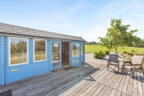 A blue cabin with a wooden deck and a view of the countryside. - 1 Bed in Beaworthy (oc-93267) (Ashwater)