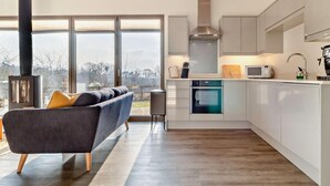A modern kitchen with a built-in oven, microwave, and stainless steel range hood. - 2 Bed in Colchester (oc-95941) (East Bergholt)