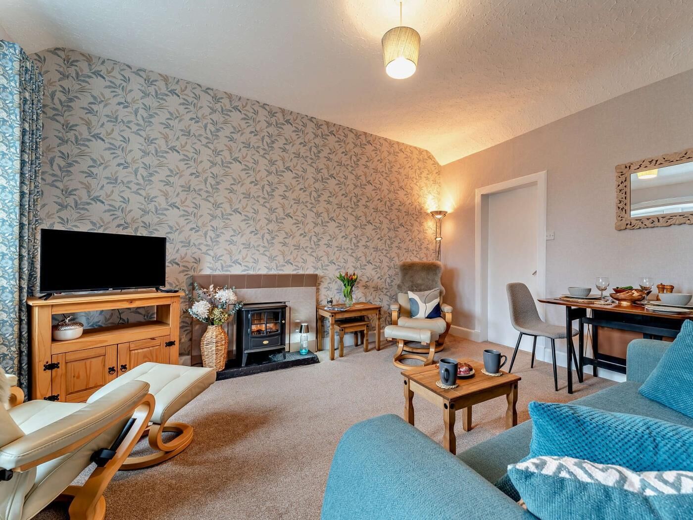 A living room with a fireplace, a television, and seating areas.