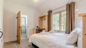 A bedroom with a bed, a wooden desk, a chair, a window with curtains, and a door leading to a balcony. - 3 Bed in King's Lynn (oc-96035) (Middleton)