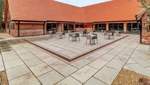 A courtyard with a tiled roof, outdoor seating, and brick walls. - 3 Bed in King's Lynn (oc-96035) (Middleton)