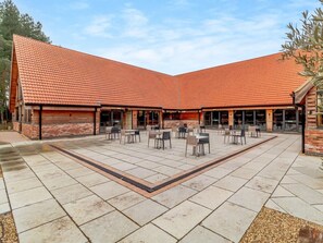 Ein Innenhof mit Ziegeldach, Außenbestuhlung und Backsteinmauern.