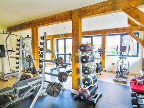 A gym with weightlifting equipment, cardio machines, and large windows. - 3 Bed in King's Lynn (oc-96036) (Middleton)