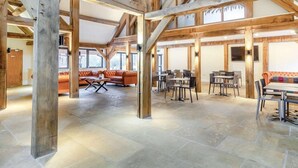 A spacious hall with high wooden beams, stone flooring, and seating areas. - 3 Bed in King's Lynn (oc-96036) (Middleton)